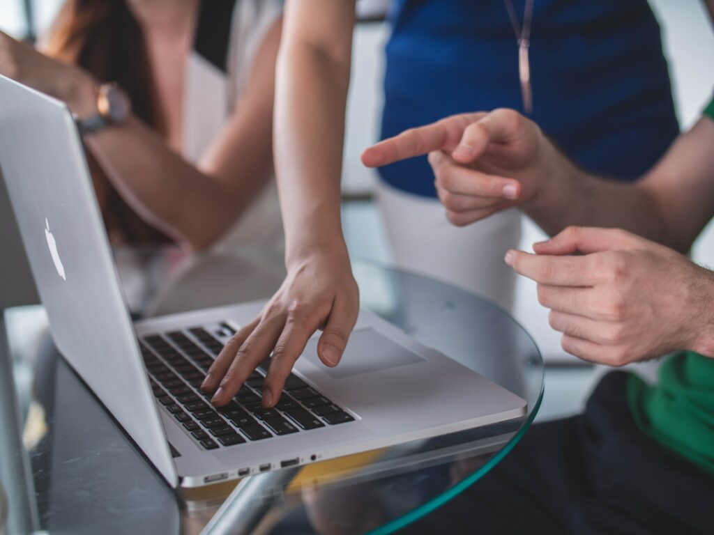 hands pointing at a laptop screen