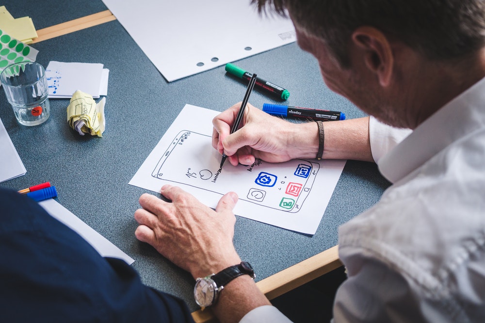 man drawing a UI design