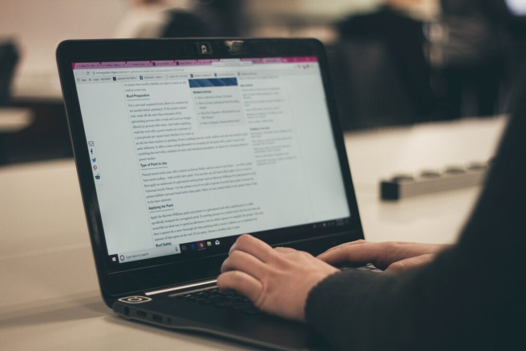 person typing content using a laptop