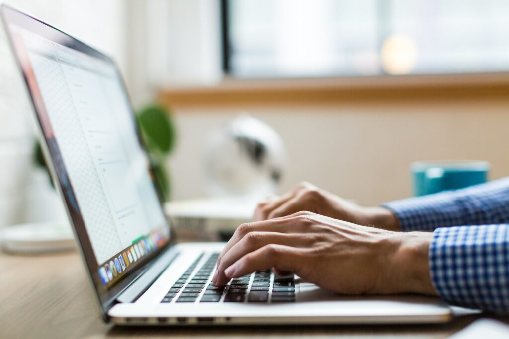 man typing in his laptop