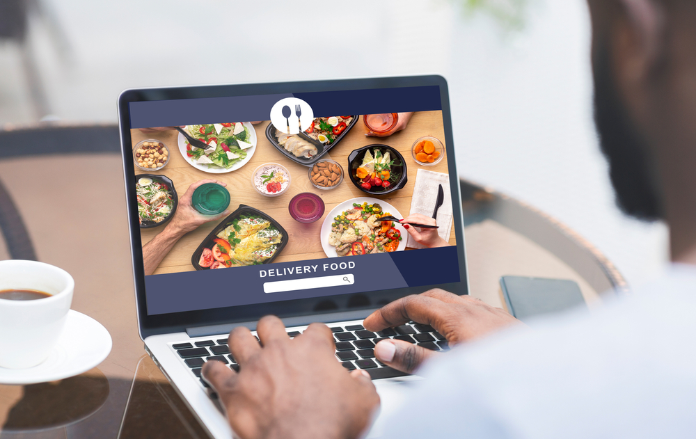 man browsing a restaurant website using his laptop