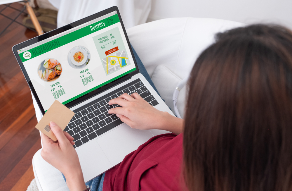 woman browsing through a restaurant website using her laptop