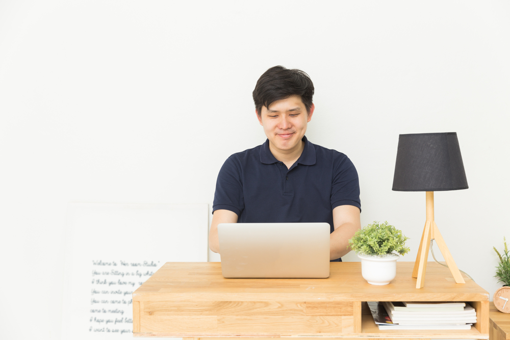 man writing content using his laptop