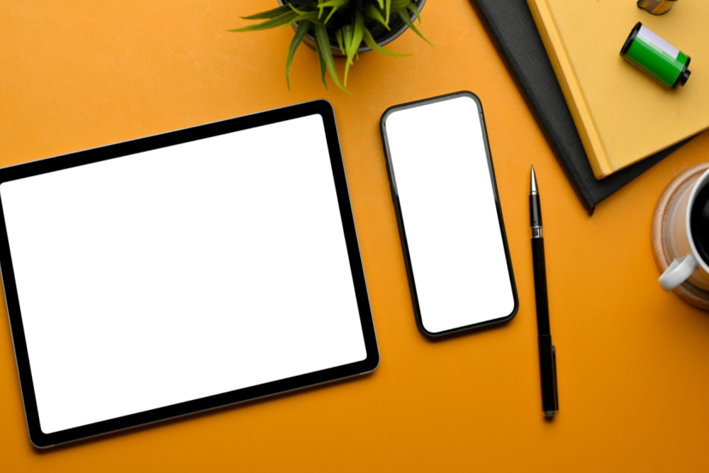 tablet and mobile phone on an orange surface