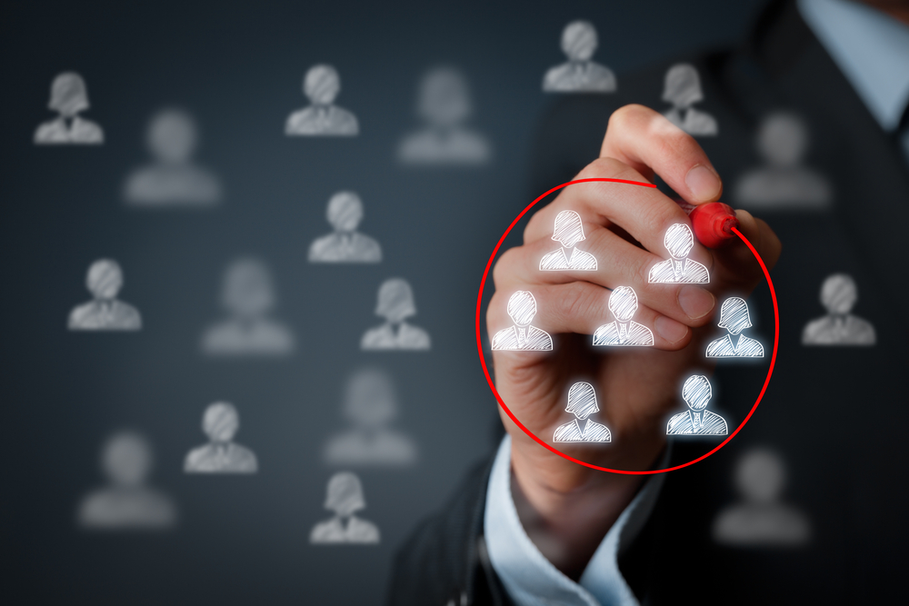 a businessman circling target customers using red marker on transparent board