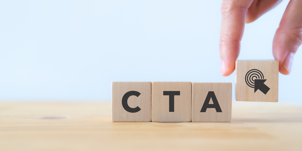 CTA letters on wooden blocks on top of table. Call to action concept