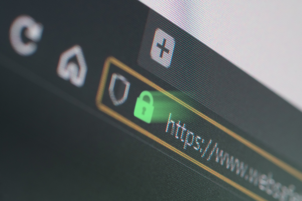 Dark web browser close-up on LCD screen with shallow focus, light shining through https padlock