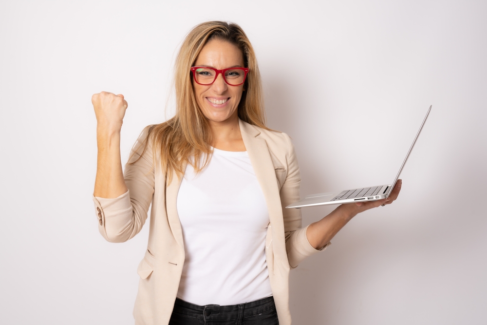 Portrait of a happy caucasian business woman while holding a laptop computer 