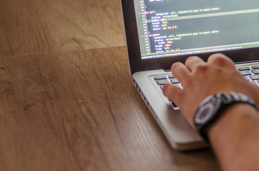 close up of web developer's hand on laptop with website codes