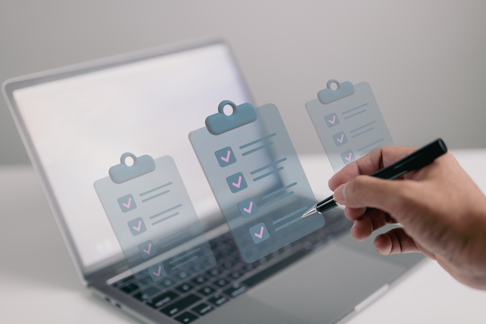 hand of a man marks a checklist hologram from laptop with a pen