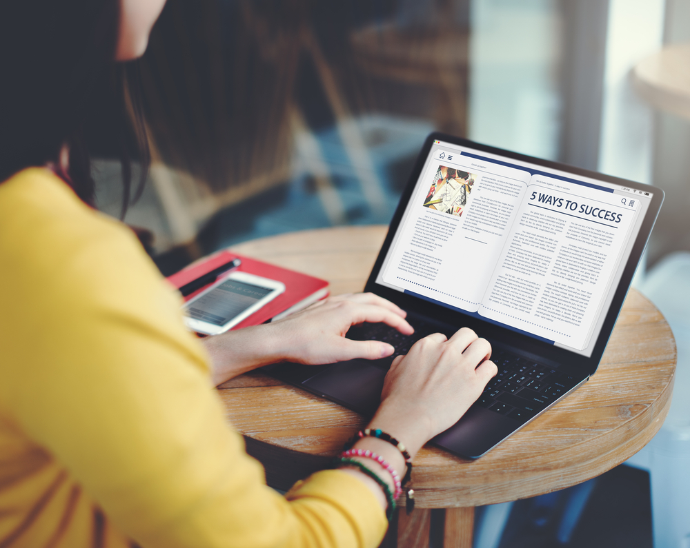 backview of a woman typing an article with 5 ways to success title