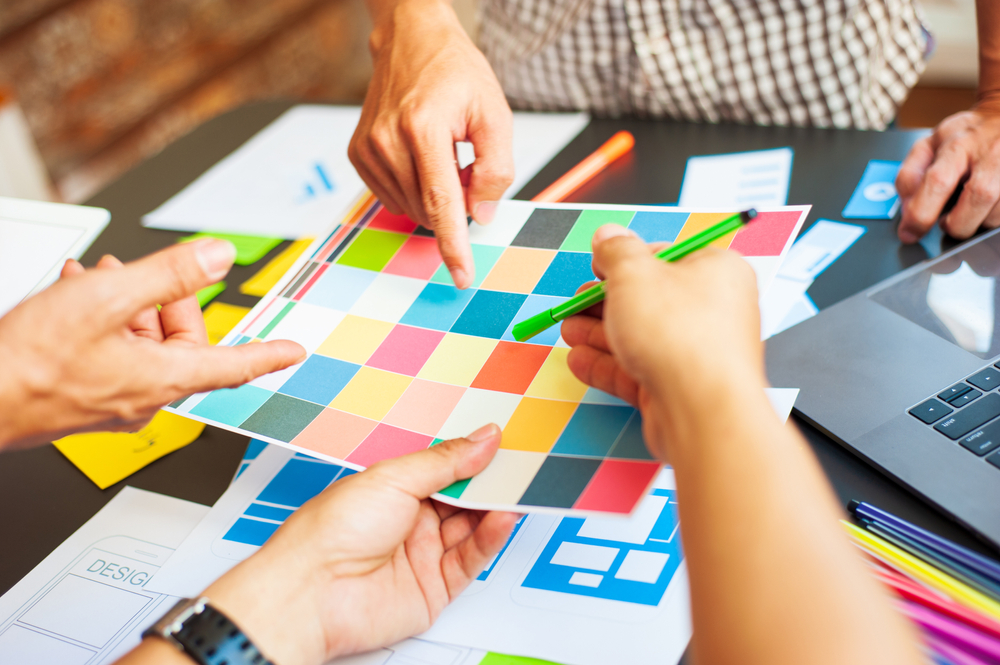 group of web designers choosing from color scheme paper