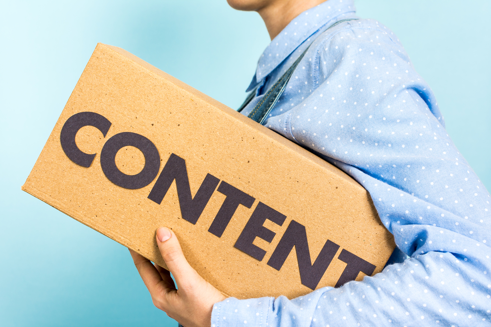 a man holding a rectangular box with Content word written on it